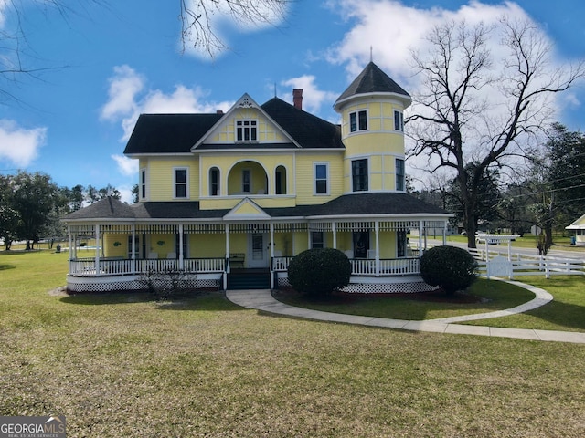 view of front facade featuring covered porch and a front yard