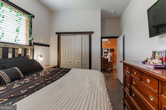 bedroom featuring concrete flooring and a closet