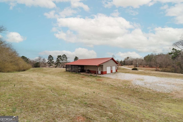 exterior space with a detached garage, a pole building, and an outbuilding