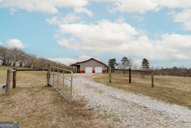 view of street featuring a gate, a rural view, driveway, and a gated entry