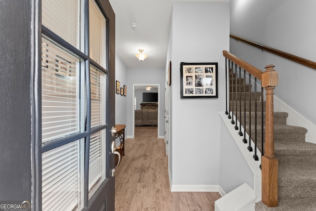 hallway with light wood-style flooring and baseboards