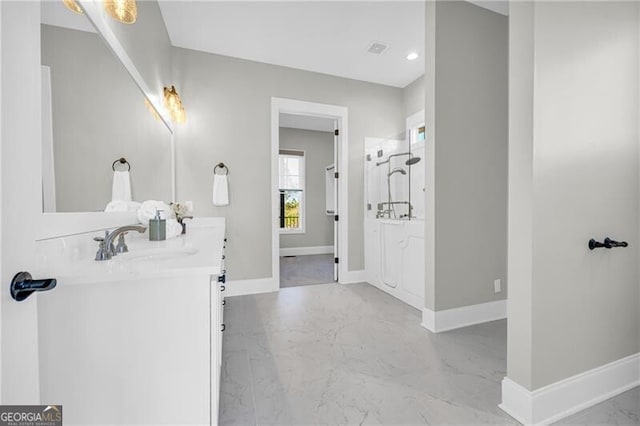 bathroom with marble finish floor, vanity, and baseboards