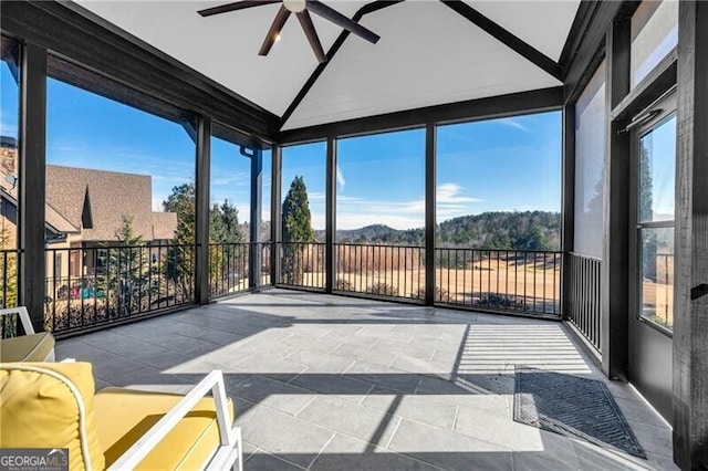 sunroom / solarium featuring lofted ceiling, ceiling fan, and a wealth of natural light