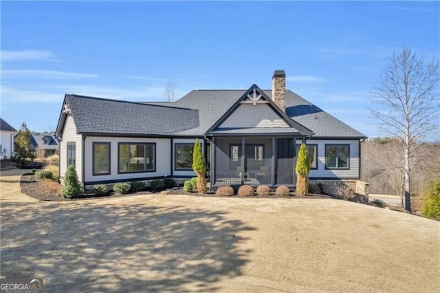 view of front facade with a sunroom and a chimney