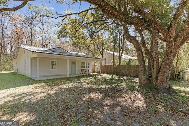 exterior space with metal roof, a yard, a patio area, and fence