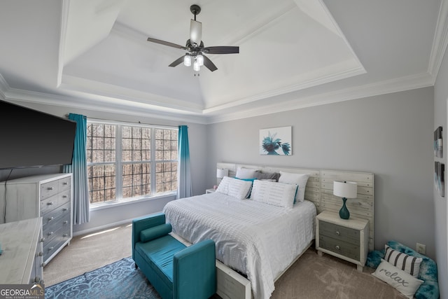 carpeted bedroom featuring ceiling fan, crown molding, and a tray ceiling