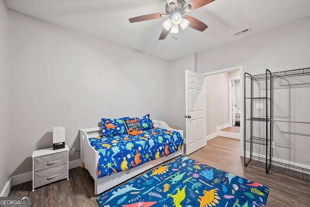 bedroom with visible vents, baseboards, and wood finished floors