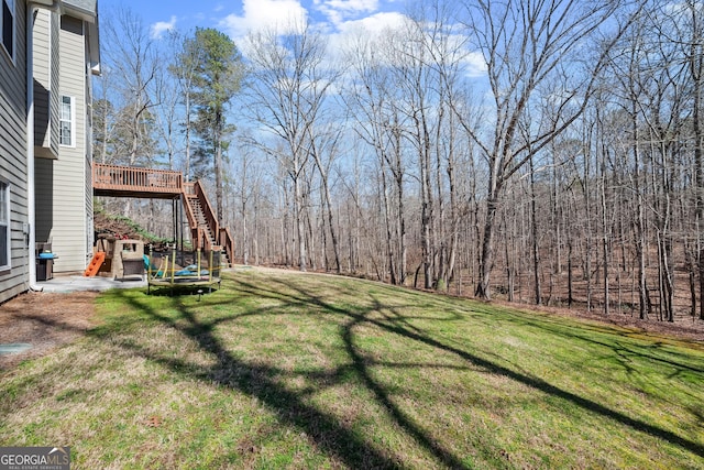 view of yard featuring a patio area, stairs, and a deck