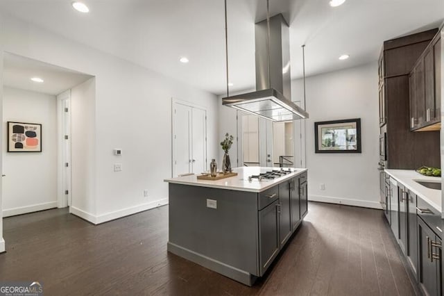 241 Maynard Ter SE Unit 17, Atlanta, GA 30316 - kitchen with dark wood-style floors, island exhaust hood, light countertops, a kitchen island, and baseboards