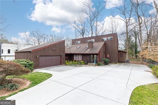 mid-century modern home featuring a garage and concrete driveway