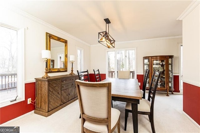 dining room featuring light carpet and crown molding