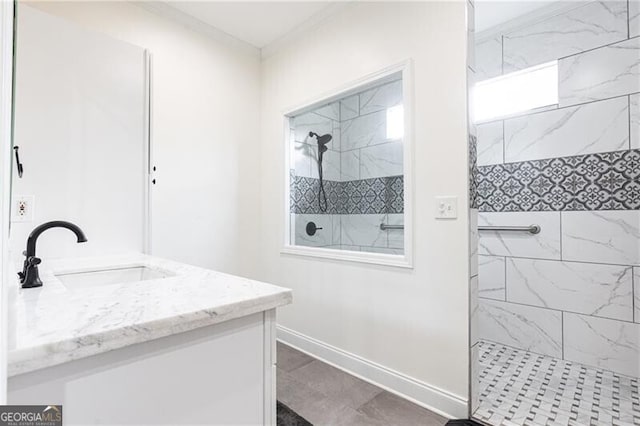 full bathroom featuring a walk in shower, ornamental molding, vanity, and baseboards