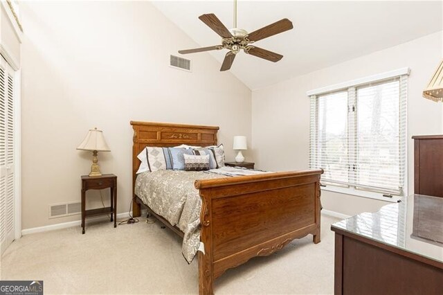 bedroom with light colored carpet, lofted ceiling, a closet, and visible vents