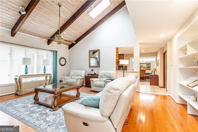 living room with light wood-style floors, wood ceiling, beam ceiling, and a skylight