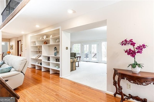 living area with french doors, light wood-type flooring, and recessed lighting