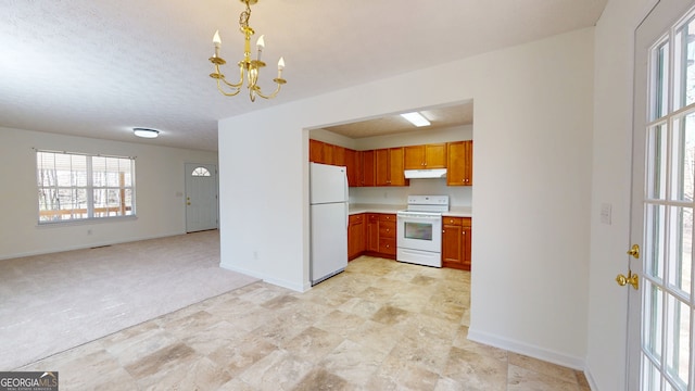 kitchen with white appliances, light countertops, under cabinet range hood, brown cabinets, and a chandelier