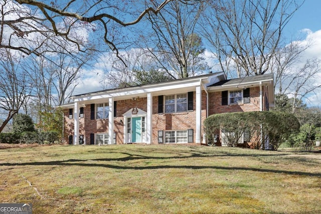 bi-level home featuring a front yard and brick siding