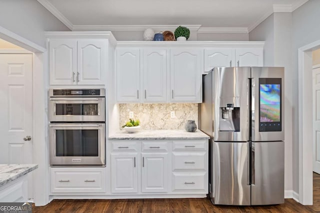 kitchen with appliances with stainless steel finishes, dark wood-style flooring, white cabinets, and light stone counters