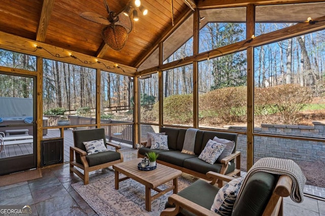 sunroom / solarium with a healthy amount of sunlight, wooden ceiling, ceiling fan, and lofted ceiling with beams