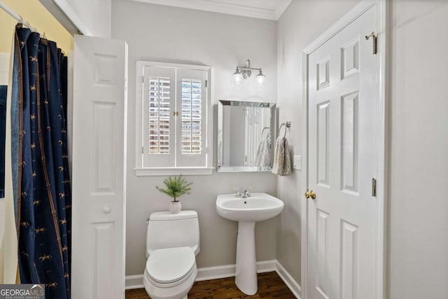 bathroom with ornamental molding, wood finished floors, toilet, and baseboards