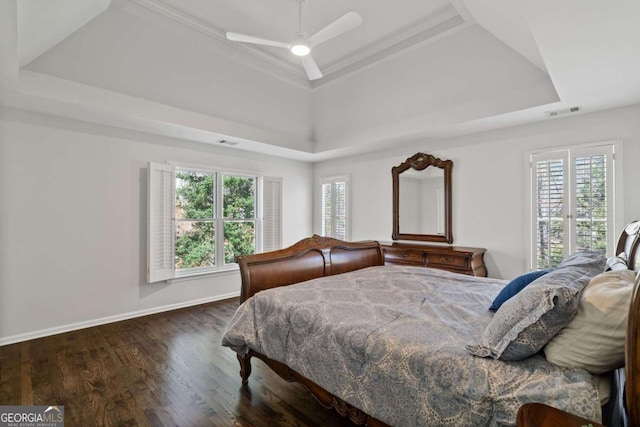 bedroom featuring baseboards, visible vents, a raised ceiling, ceiling fan, and wood finished floors