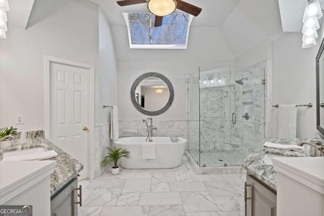 bathroom with marble finish floor, tile walls, lofted ceiling, a sink, and a shower stall