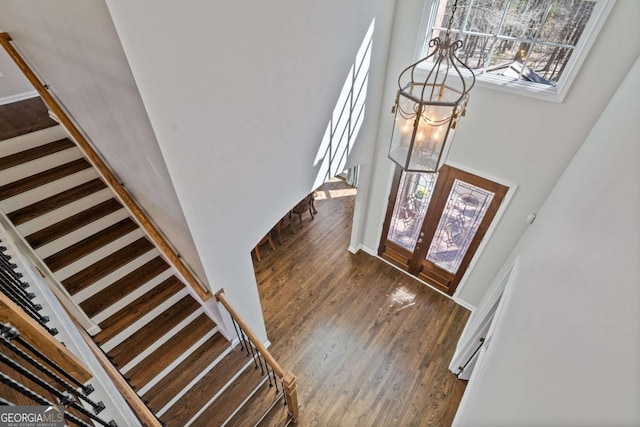 entrance foyer with stairs, french doors, and wood finished floors