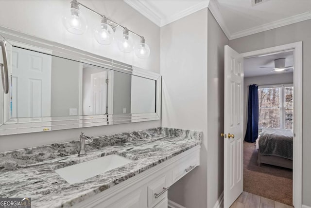 bathroom with baseboards, wood finished floors, vanity, and crown molding