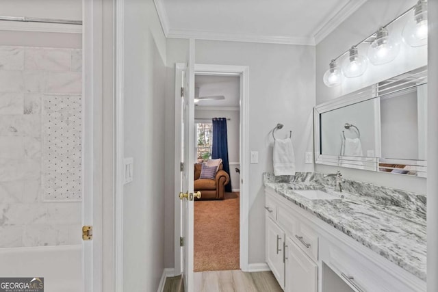 bathroom featuring a shower, crown molding, vanity, and baseboards