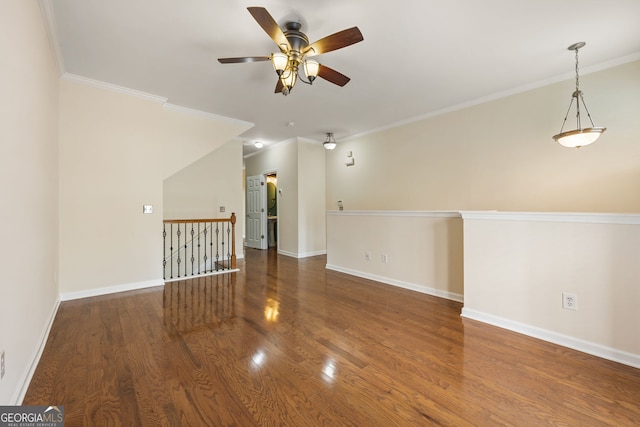 empty room featuring baseboards, wood finished floors, and ornamental molding