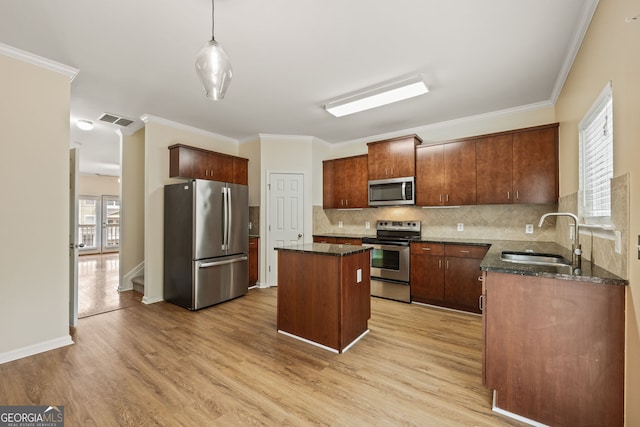 kitchen featuring a sink, visible vents, appliances with stainless steel finishes, a center island, and light wood finished floors