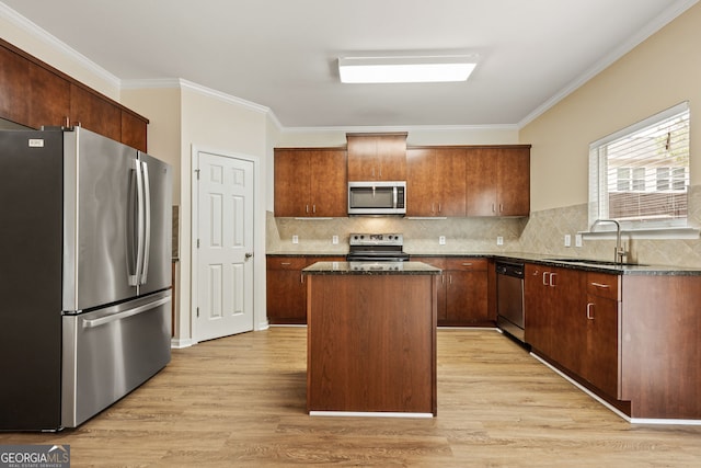 kitchen featuring stainless steel appliances, a center island, light wood-type flooring, and a sink