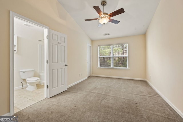 unfurnished bedroom featuring lofted ceiling, visible vents, carpet flooring, and ensuite bathroom