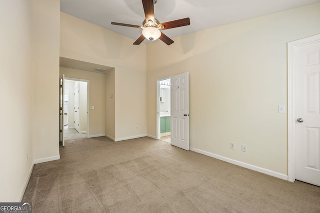 unfurnished bedroom featuring ceiling fan, carpet, connected bathroom, and baseboards