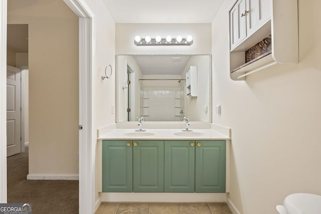 full bathroom with double vanity, baseboards, a shower, and a sink