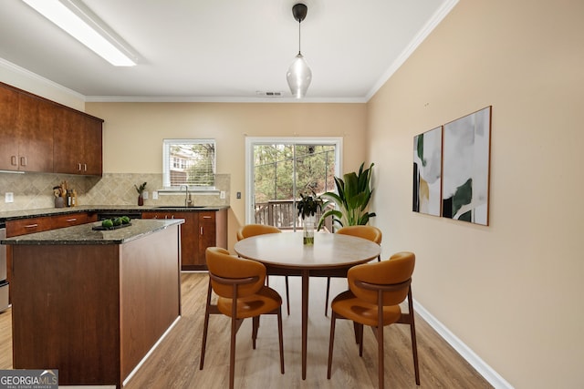 dining space featuring baseboards, ornamental molding, visible vents, and light wood-style floors