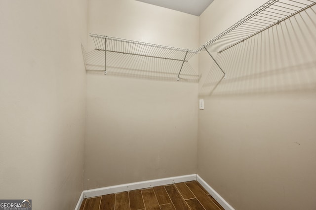 spacious closet with dark wood-style floors