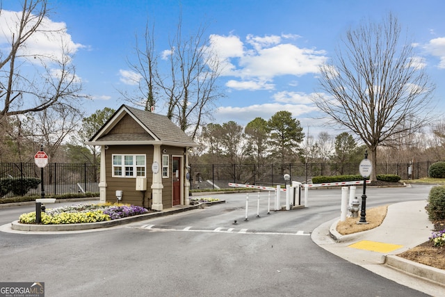 view of street with curbs, a gated entry, traffic signs, and a gate