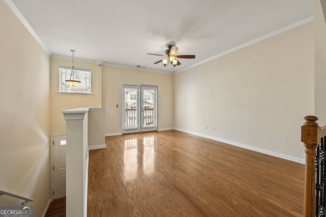 unfurnished living room featuring crown molding, visible vents, baseboards, and wood finished floors