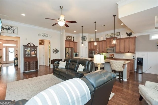 living area featuring crown molding, a ceiling fan, dark wood-type flooring, and recessed lighting