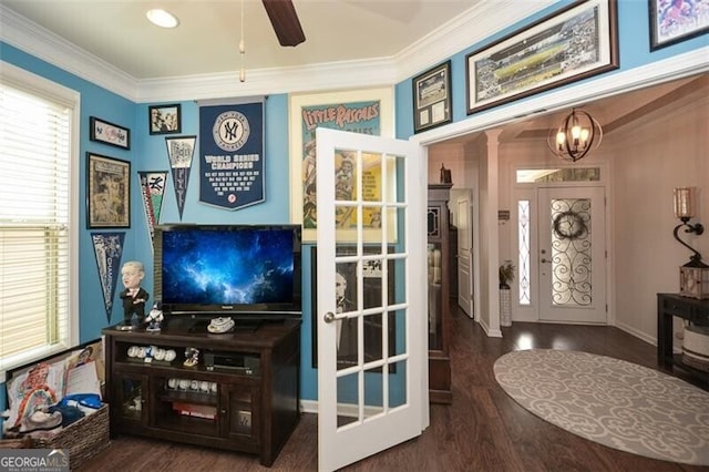 interior space with ornamental molding, ceiling fan with notable chandelier, and wood finished floors