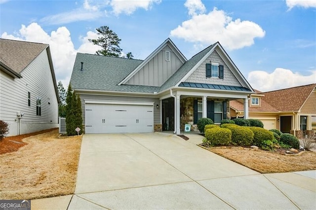 craftsman inspired home with board and batten siding, concrete driveway, stone siding, and a garage