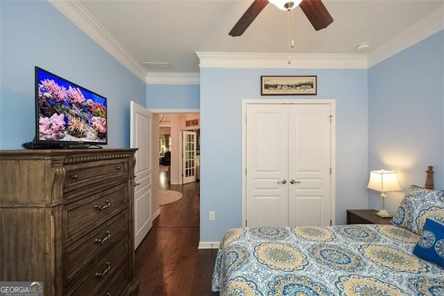 bedroom with visible vents, dark wood finished floors, a ceiling fan, crown molding, and a closet