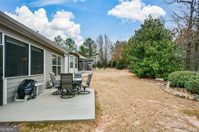 view of yard with a sunroom and a patio area