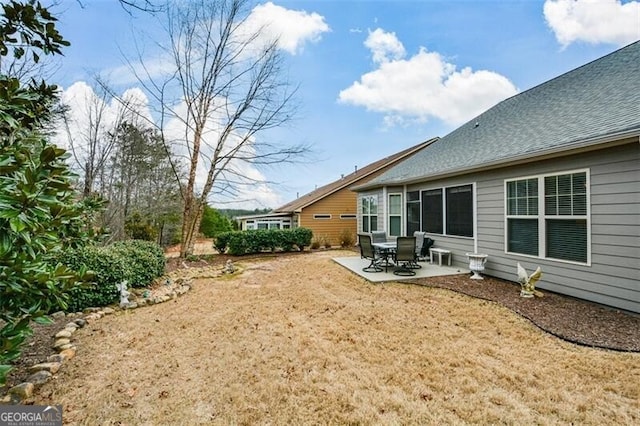 back of house with roof with shingles and a patio area