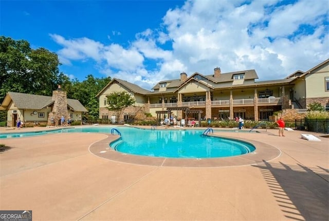 community pool with a patio and fence