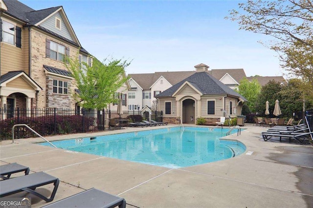 pool with a patio and fence