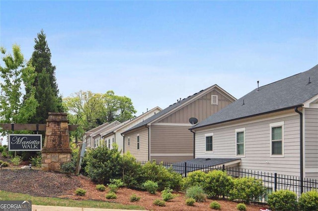 view of side of home with fence and board and batten siding