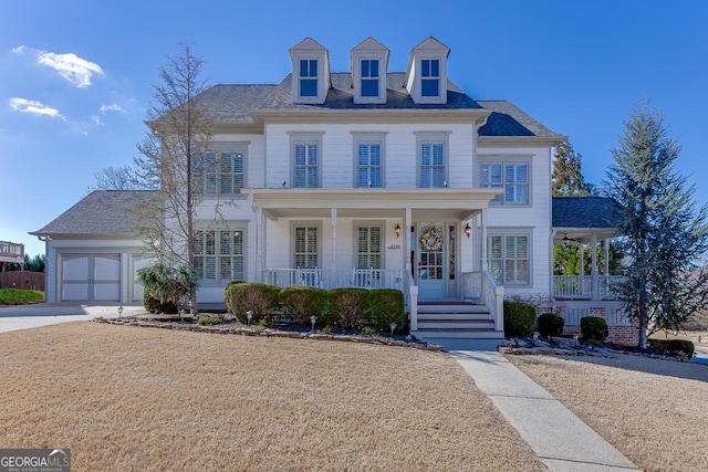 colonial inspired home with a garage, driveway, and a porch