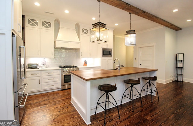 kitchen with custom range hood, wood counters, beamed ceiling, stainless steel appliances, and a sink